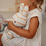 A child wearing a Vintage Sunny Stripes outfit gently grips the Miffy Plush Vintage Stripes All Over - 25cm toy, bringing to mind a Little Dutch collaboration.