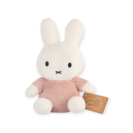 The Miffy Plush Fluffy Plush Pink - 25cm, by Miffy, is a delightful plush bunny toy featuring a white head and limbs along with a fluffy pink body. It's ideal for nursery decor and sits upright with a small tag attached to the side.