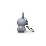 The Miffy Keychain - Powder by Miffy showcases a gray, rabbit-shaped charm, accompanied by a metal chain and ring, elegantly viewed from the side. Its minimalist design provides a modern twist on this classic accessory.