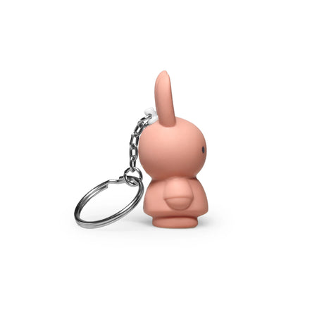 The Miffy Keychain - Powder by Miffy is a small, pink, rabbit-shaped keychain with a metal chain and ring. It features a minimalist design that modernizes the classic look of the Miffy Bunny Keychain and is depicted from the side against a white background.