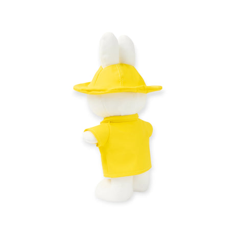 Rear view of Miffy plush dressed in bright yellow raincoat and hat, ears visible, standing upright, gallery position 1