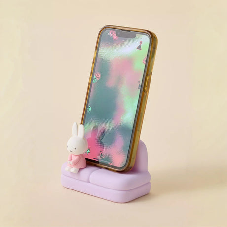 Miffy phone stand with purple base and white bunny figure beside a phone
