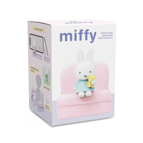Miffy figure in blue outfit holding teddy bear seated on pastel pink mini sofa stand with packaging box