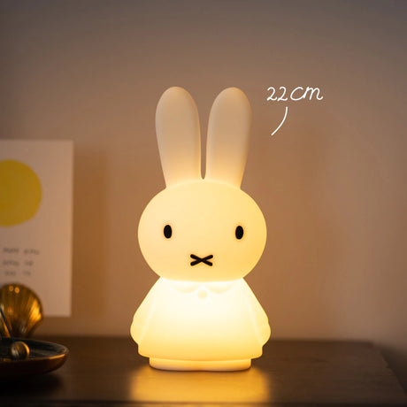 The 22cm Miffy Shines Night Light, shaped like a bunny, emits a glow on the table with touch-sensitive dimming.