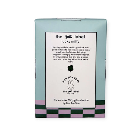 A green and purple box features printed text about the "Mini Miffy Plush - Grey Lucky Charm" from the brand Miffy. This plush toy is a soft and cuddly lucky charm, suitable for all ages.