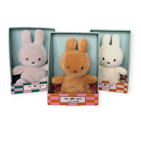 Three delightful Mini Miffy Plush toys from the Miffy brand come nestled in pastel-colored boxes. These charming toys feature pink, brown, and white versions with "Miffy" elegantly displayed on the label, offering a gift-worthy allure that makes them a delightful addition to any collection.