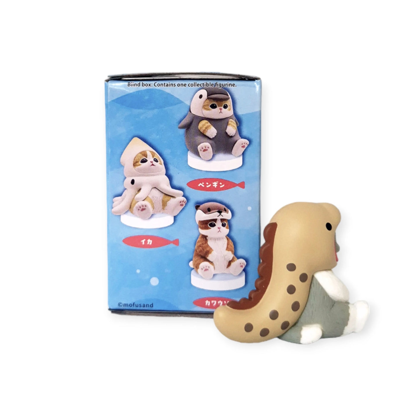 A Mofusand toy figure of an otter dressed as a dinosaur is displayed next to the Mofusand Premium - Aquarium Cat Blind Box, which features three collectible animal figurines in costumes: a penguin, a squid, and a capybara.