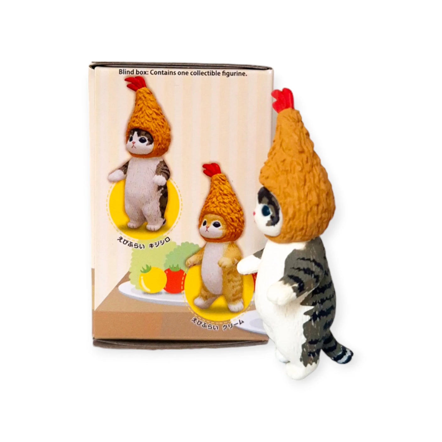 A small cat figurine donning an orange chicken hat is displayed next to a Mofusand Premium - Fried Shrimp Cat Blind Box, showcasing the same character. As part of the Fried Shrimp Series by Mofusand, it's certain to enchant fans who adore cat-themed food items.