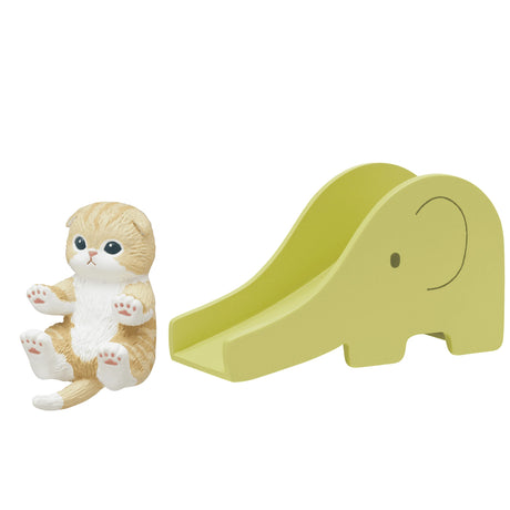 A delightful toy ginger kitten from the Mofusand Premium Blind Box - Cats on Slides series sits contentedly beside a yellow elephant-shaped slide.