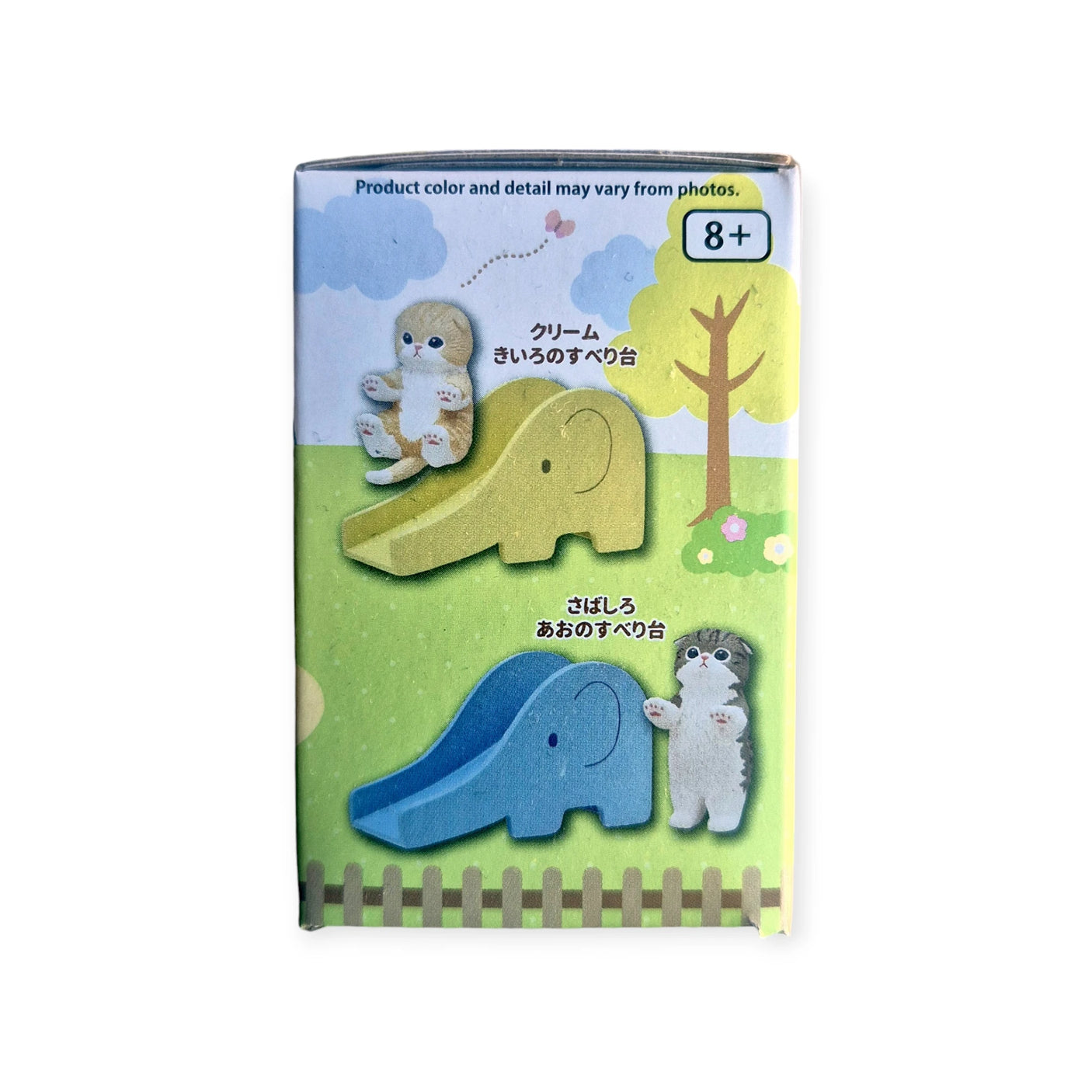 The Mofusand Premium Blind Box - Cats on Slides features a charming toy box displaying an elephant-shaped slide in yellow and blue, complemented by mini cat figures. A picturesque backdrop of sky, tree, and grass enhances the scene. Ideal for ages 8 and up, this surprise from Mofusand is sure to delight.