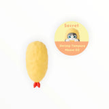 Yellow shrimp-shaped Hippers figurine with a red bow and white face detail