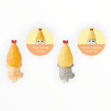 Pair of plush shrimp hippers with yellow hoods and red bows, with gray bottoms.