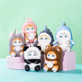 Assorted pastel kitten plush keychains displayed together on stacked boxes