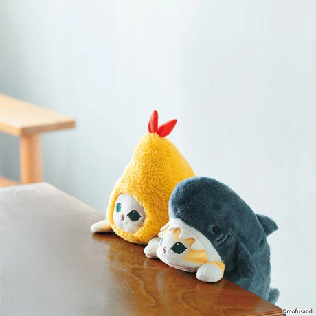 Blue shark plush buddy lying down on a bench, with a yellow character nearby