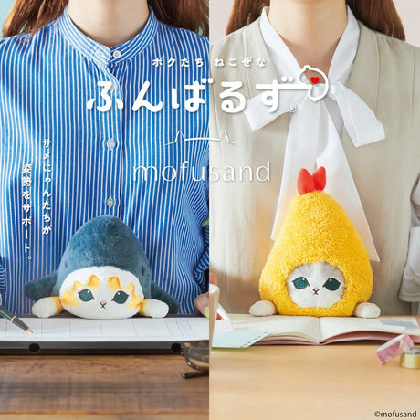 Blue shark plush buddy with white belly on a desk, beside an open book