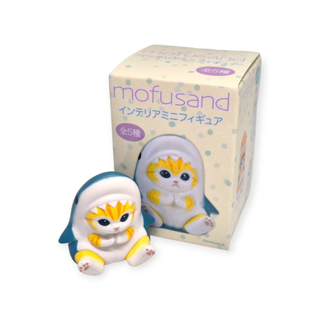 A charming Mofusand Mini Figure Blind Box - Vol 1 (Yellow) features a delightful small figure of a cat dressed in a penguin costume. The blind box is decorated with Japanese text and images of adorable figures by the talented Juno, renowned as the cat artist.