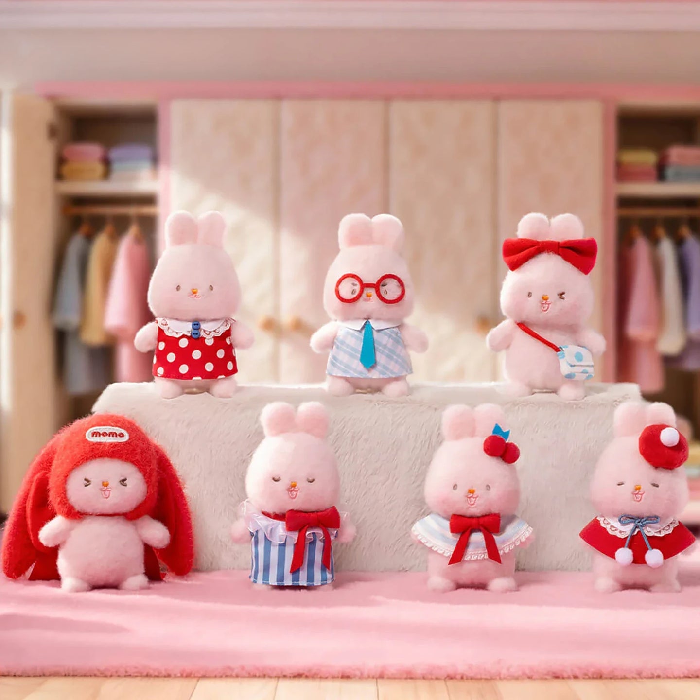 Assorted pink plush bunny keychains in different outfits on a shelf display