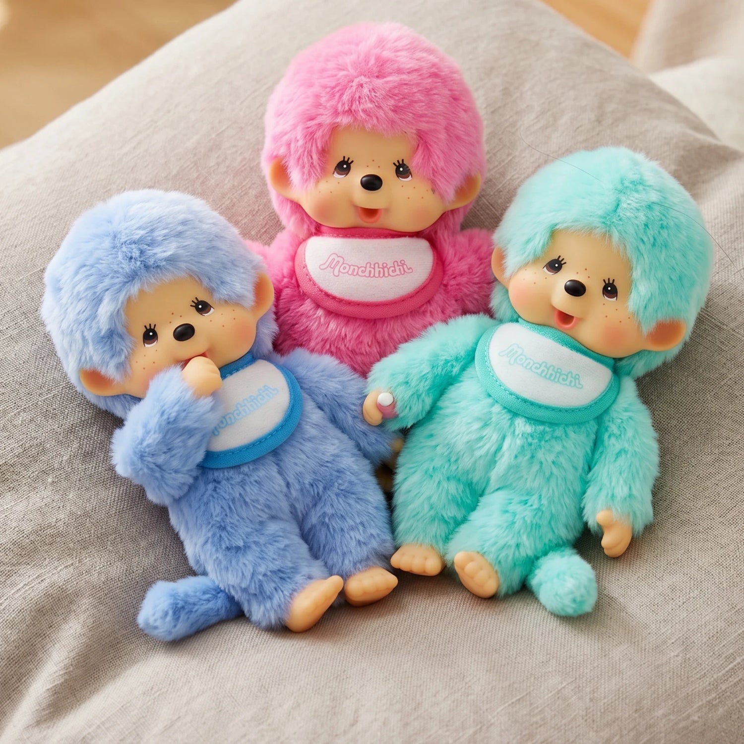 Three plush dolls together: pink, light blue, and mint with bibs and hoods