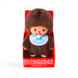Monchhichi plush doll with brown fur, blue bib and pacifier, in display box