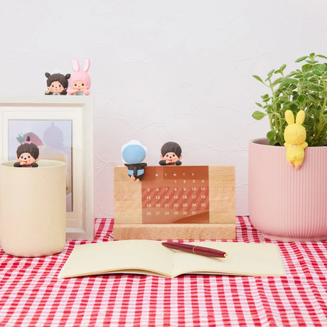 Five Monchhichi Hippers figures clinging to various objects on red checkered tablecloth, promo image one