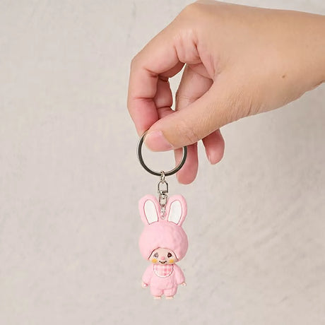 Pink bunny keychain held in hand, small mini figure wearing plaid outfit