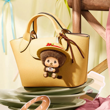 Gold tote bag charm: small brown Monchhichi pendant figure in straw hat