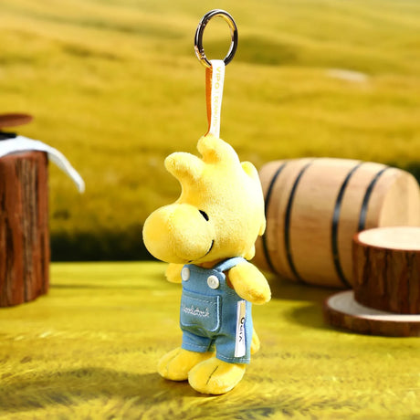 Yellow Woodstock denim plush keychain with light blue overalls and metal ring