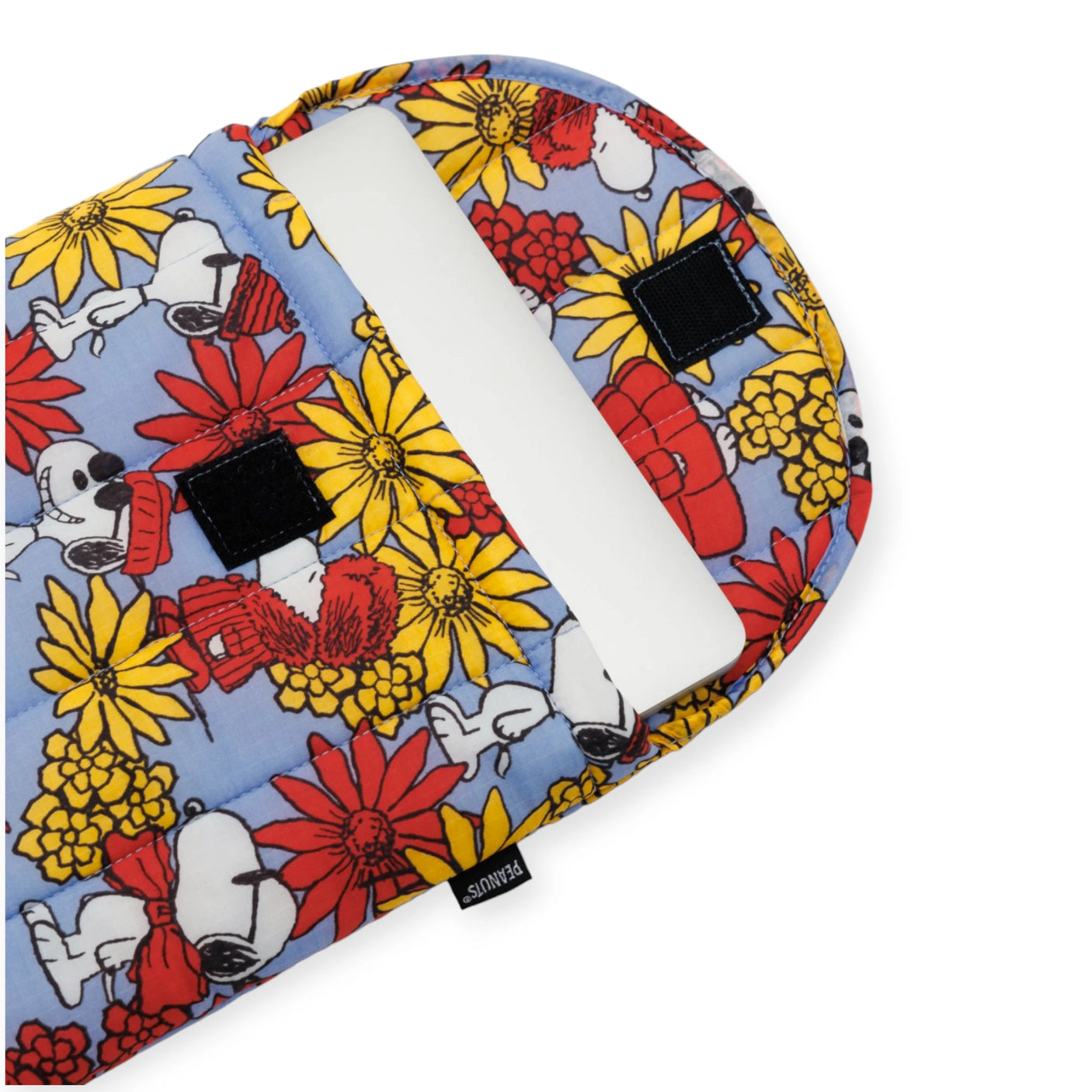 The Peanuts x Baggu Laptop Sleeve - Snoopy Floral 13"/14", crafted by Baggu from 100% recycled materials, showcases lively Snoopy Floral patterns adorned with cartoon dogs and flowers. The open flap reveals a white laptop nestled securely inside.