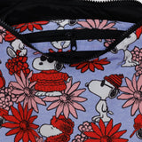 The Baggu x Peanuts - Medium Crescent Bag Floral Snoopy features a vibrant fabric adorned with cartoon dogs in winter attire surrounded by red and pink flowers, complete with a small zippered pocket at the top.