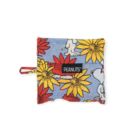 The Baggu Standard - Peanuts Floral Snoopy is a square pouch made from recycled nylon, showcasing a vibrant design of red and yellow flowers on a blue background, complete with delightful images of Snoopy. It features the Peanuts label and functions as a practical reusable bag from Baggu.