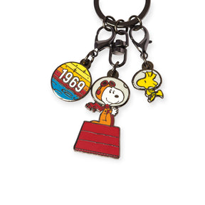 The Snoopy & Woodstock in Space Keychain by Snoopy features three charms: a round "1969" charm, NASA Snoopy in an astronaut suit on a red box, and Woodstock—a collectible Peanuts must-have.