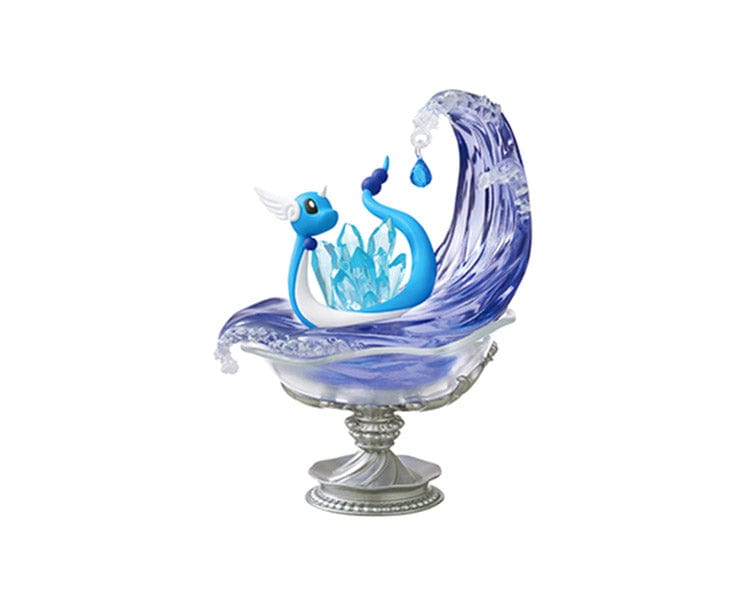 A piece from the Re-Ment Pokemon Gemstone Collection 2 features a blue serpent-like figure on a decorative base, evoking the essence of a rare Pokémon Gemstone, encompassed by a large, translucent wave.