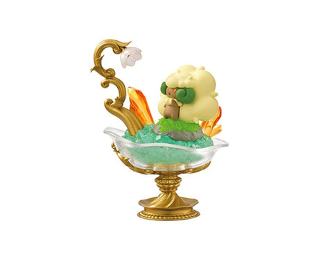 A playful figure from the Re-Ment Pokemon Gemstone Collection 2 features a fluffy character on a glass pedestal, decorated with foliage and orange accents, capturing the enchanting charm typical of collectible figures by Re-Ment.