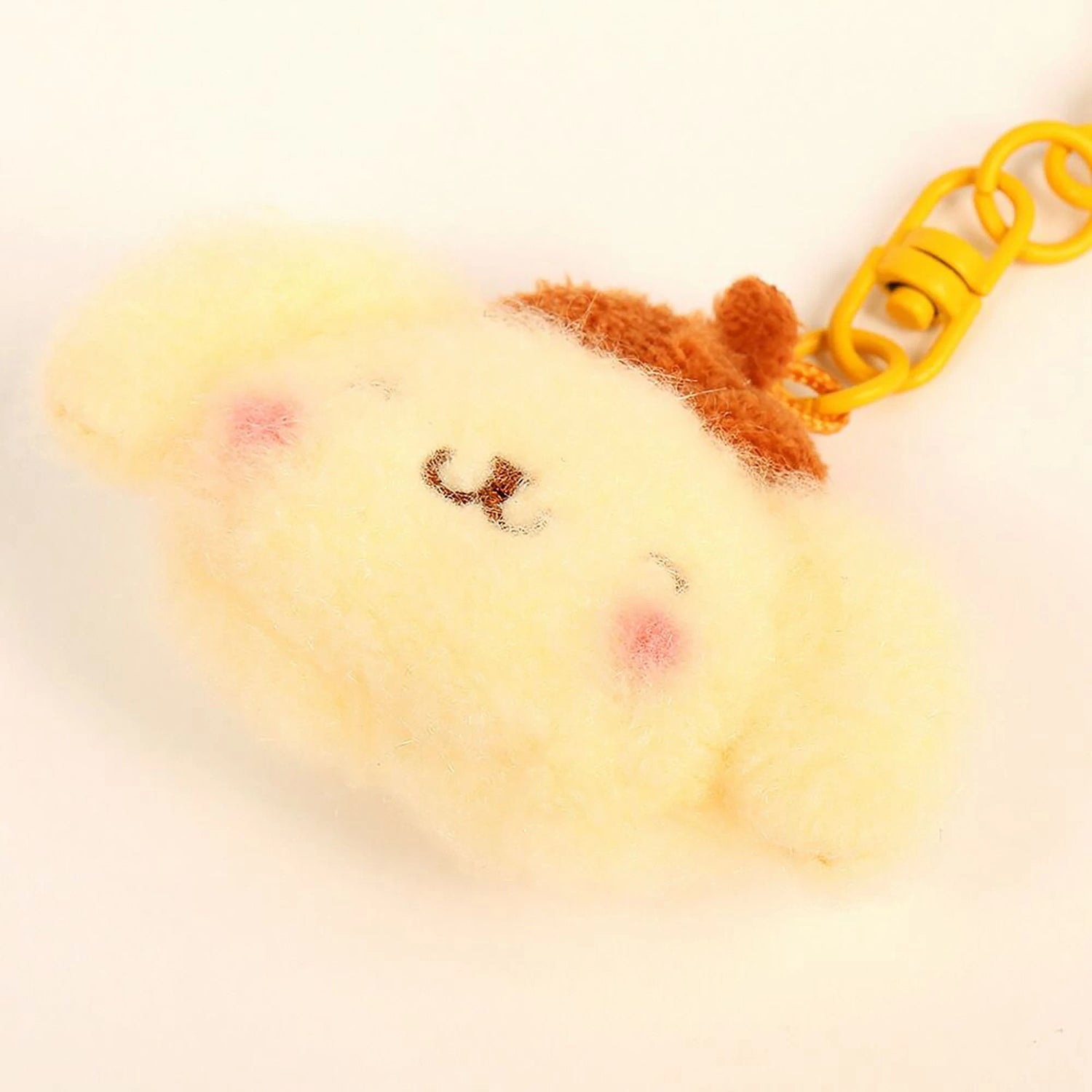 Mini plush keychain: yellow character face with brown cap, attached to orange key ring
