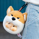 Plush dog keychain face with orange-and-white fur, black nose, black hanging strap