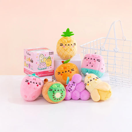 Introducing the Pusheen Blind Box - Fruits Series by Pusheen, featuring a charming assortment of fruity plush toys designed to resemble pineapple, strawberry, kiwi, grapes, and apple. Perfectly showcased alongside a white wire basket and product box, these delightful items also come with collectible keyrings for added charm.