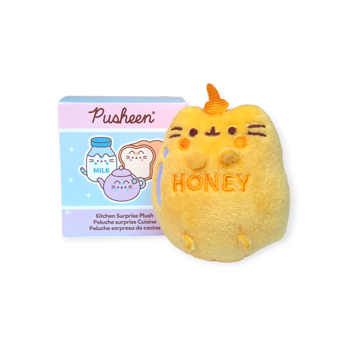 Beside a plush toy designed as a honey jar with "HONEY" embroidered on it is a Pusheen Blind Box from the Kitchen Surprise Series, featuring kitchen-themed illustrations.