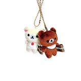 Mini plush keychain duo: white and brown bears with ribbon tags, on gold chain