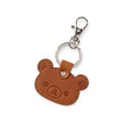 The Rilakkuma Leather Keychain is a Japan-made brown bear-shaped keychain with exquisite stitching and embossed face details, attached to a metal ring and clasp hook. It adds a charming touch to your accessories.