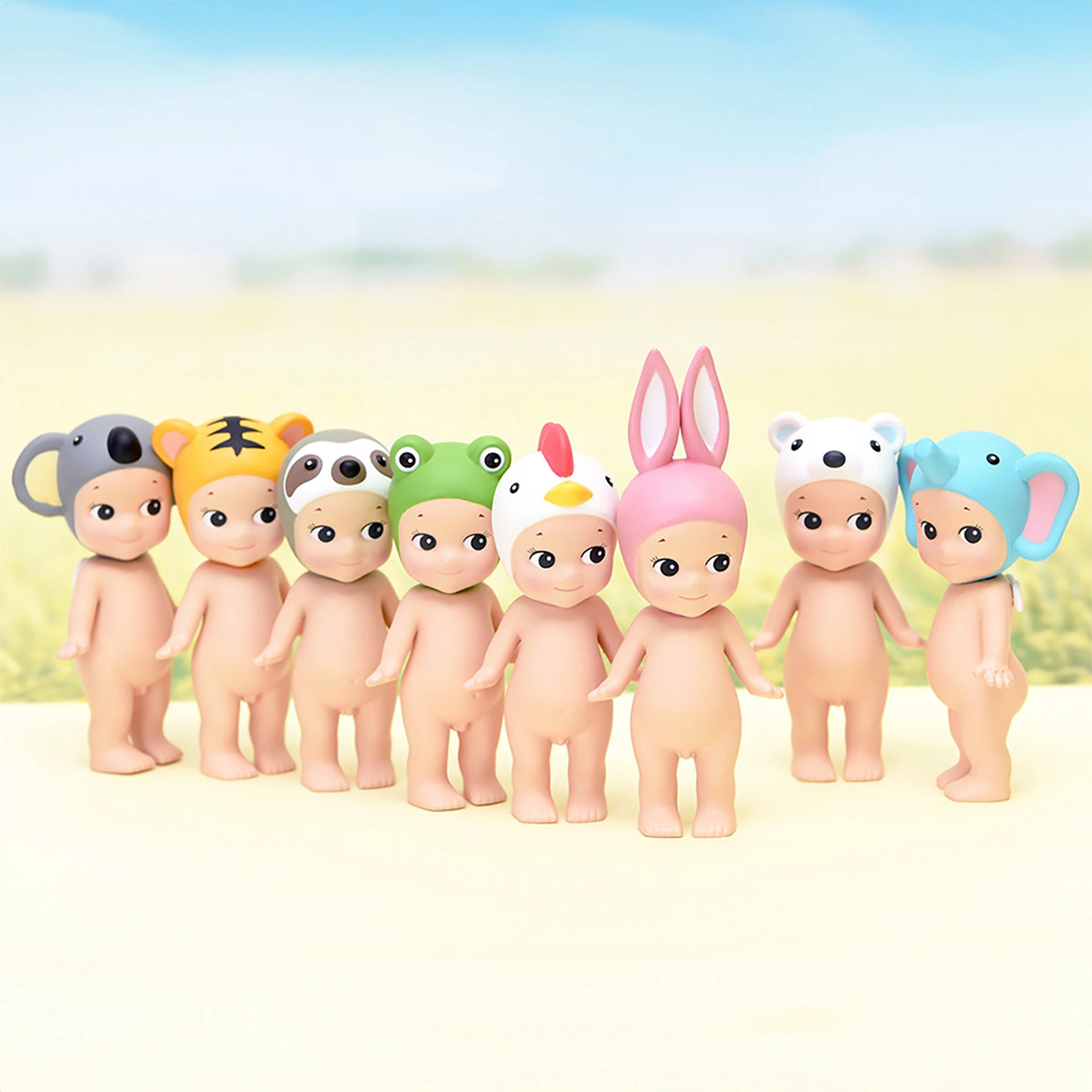 Seven adorable figures from the Sonny Angel Animal Version 1 Series by Sonny Angel are displayed outdoors, each donning whimsical animal-themed hats against a softly blurred background—a delightful scene for collectors.