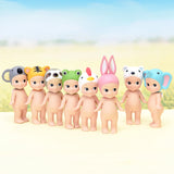 Seven adorable figures from the Sonny Angel Animal Version 1 Series by Sonny Angel are displayed outdoors, each donning whimsical animal-themed hats against a softly blurred background—a delightful scene for collectors.