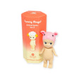 A small doll with a pink pig hat stands next to a hexagonal orange Blind Box displaying "Sonny Angel Animal Version 2 Series" by the brand Sonny Angel.