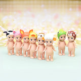 A lineup of seven Sonny Angel figurines from the Sonny Angel Animal Version 2 Series, each donning delightful animal-themed hats such as cow, pig, deer, duck, sheep, frog, and bear. They are cutely arranged on a pastel-colored surface.