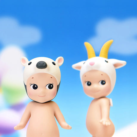 Two Sonny Angel Animal Version 4 Series dolls, one sporting a white bear hat and the other wearing a goat hat, stand against a backdrop of a blue sky with clouds, beautifully showcasing the charm of these collectible figures from Sonny Angel.