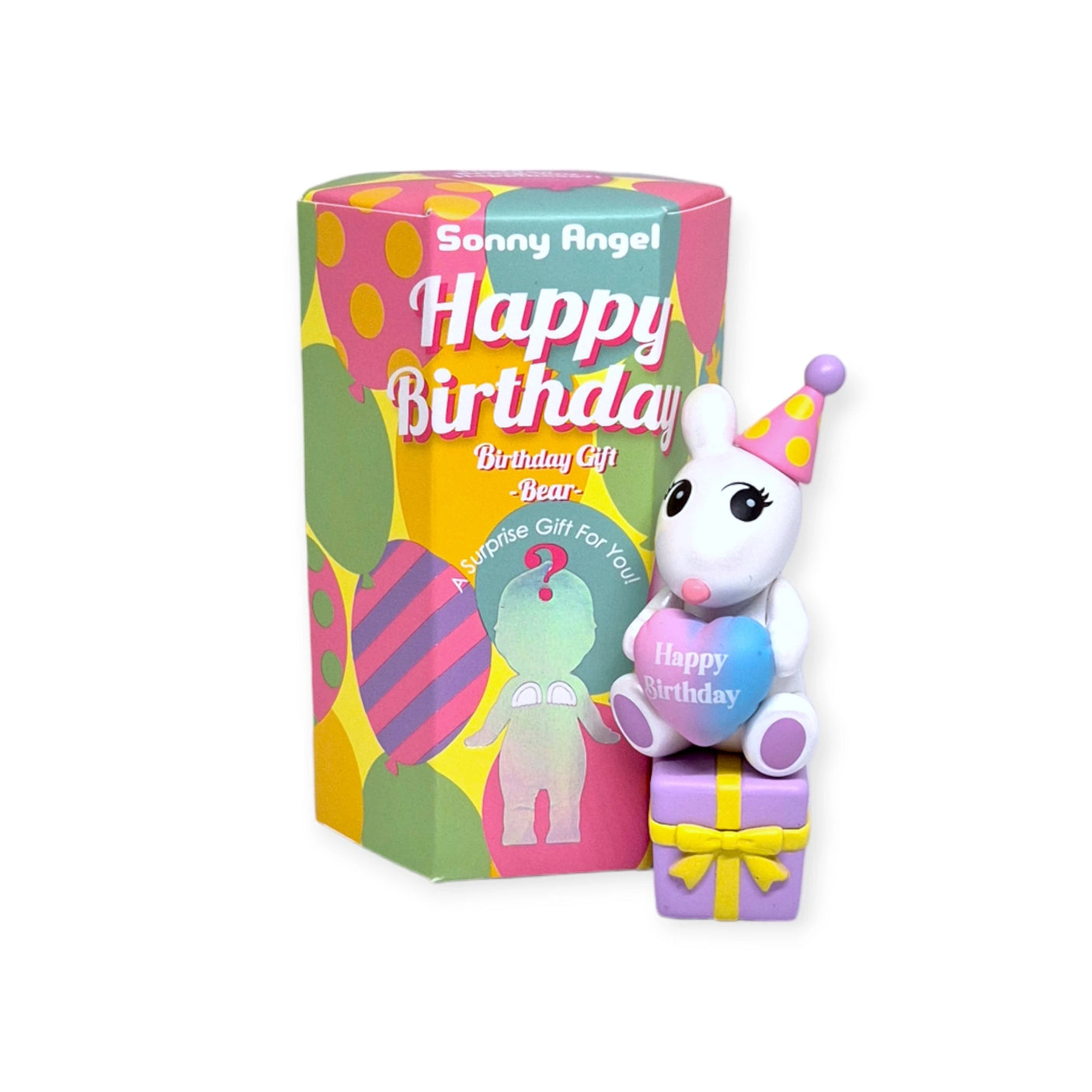 A vibrant toy bear from the Sonny Angel Birthday Bear Gift collection wears a festive party hat and holds a "Happy Birthday" heart while sitting atop gift boxes. Next to it, a cylindrical package displays the cheerful "Sonny Angel" design, making it an ideal whimsical gift for any celebration.