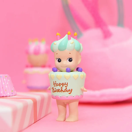 The Sonny Angel Happy Birthday Cake Gift by Sonny Angel is a delightful collectible featuring an adorable character dressed in a cake costume with "Happy Birthday" text. Surrounded by pink party decorations and wrapped gifts, this charming figurine brings joyful surprise to any celebration.