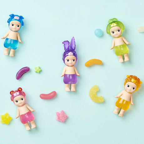 Five Sonny Angel figures from the Candy Store Series, each wearing charming animal hats, are arranged on a light blue background alongside playful candy shapes.