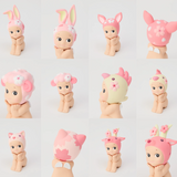 The Sonny Angel Cherry Blossom Series by Sonny Angel features 12 limited edition figurines in a 3x4 grid, each wearing animal-themed hats with pastel designs like bunnies, lambs, and birds, enchanting both new and seasoned collectors.