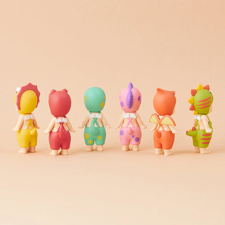 Six Sonny Angel figurines from the limited edition Dinosaur Series stand in a row on a beige background, their backs to us. Featuring colorful, animal-themed costumes, these prehistoric pals by Sonny Angel capture imaginations with delightful charm and vintage flair.