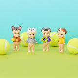 Four collectible figures from the Sonny Angel Dog Time Series, each dressed as a dog with a tennis ball, are showcased against a vibrant two-toned green and blue backdrop, perfectly capturing the playful essence of the series.